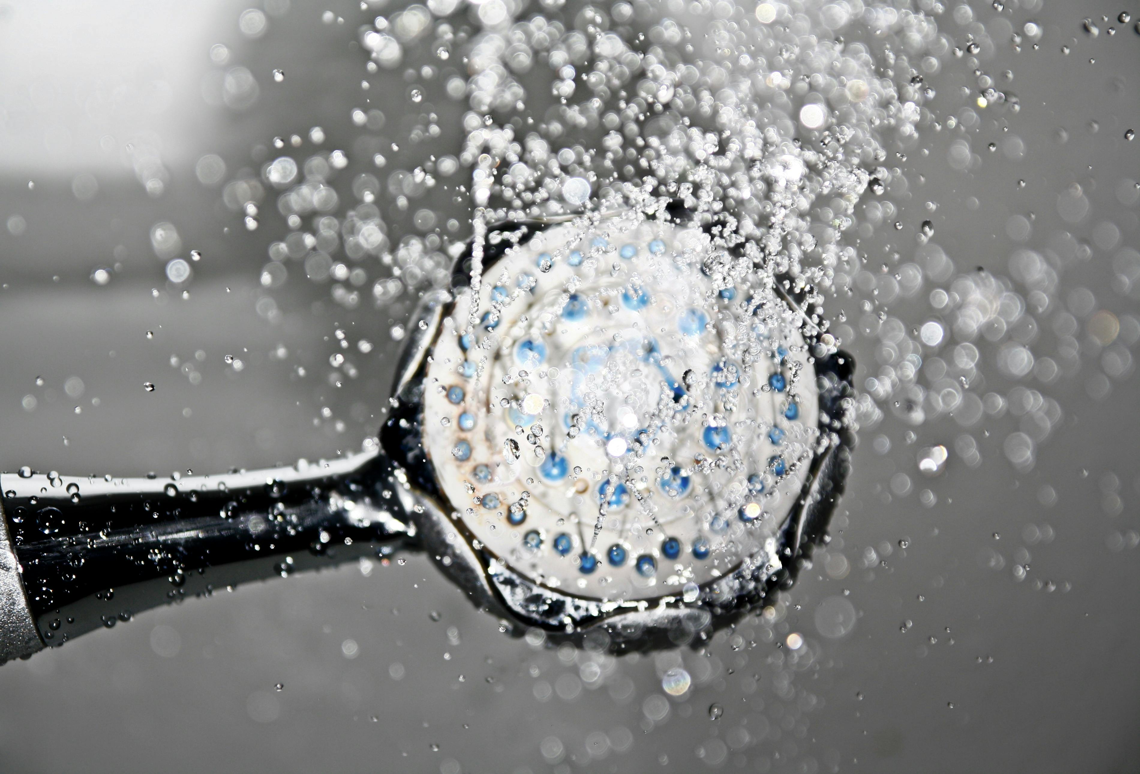 A black shower head switched on