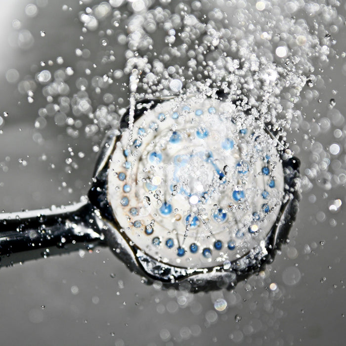 A black shower head switched on