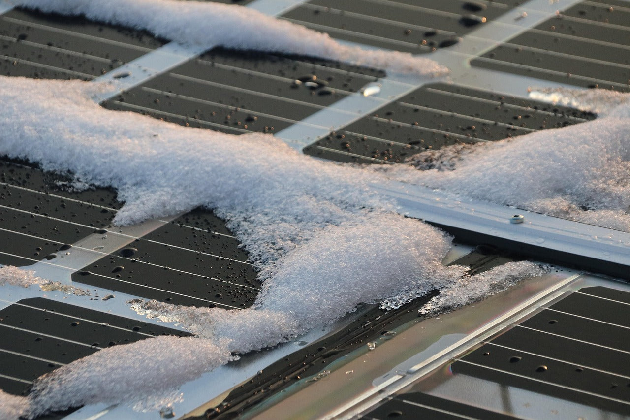 solar panels topped with melting snow