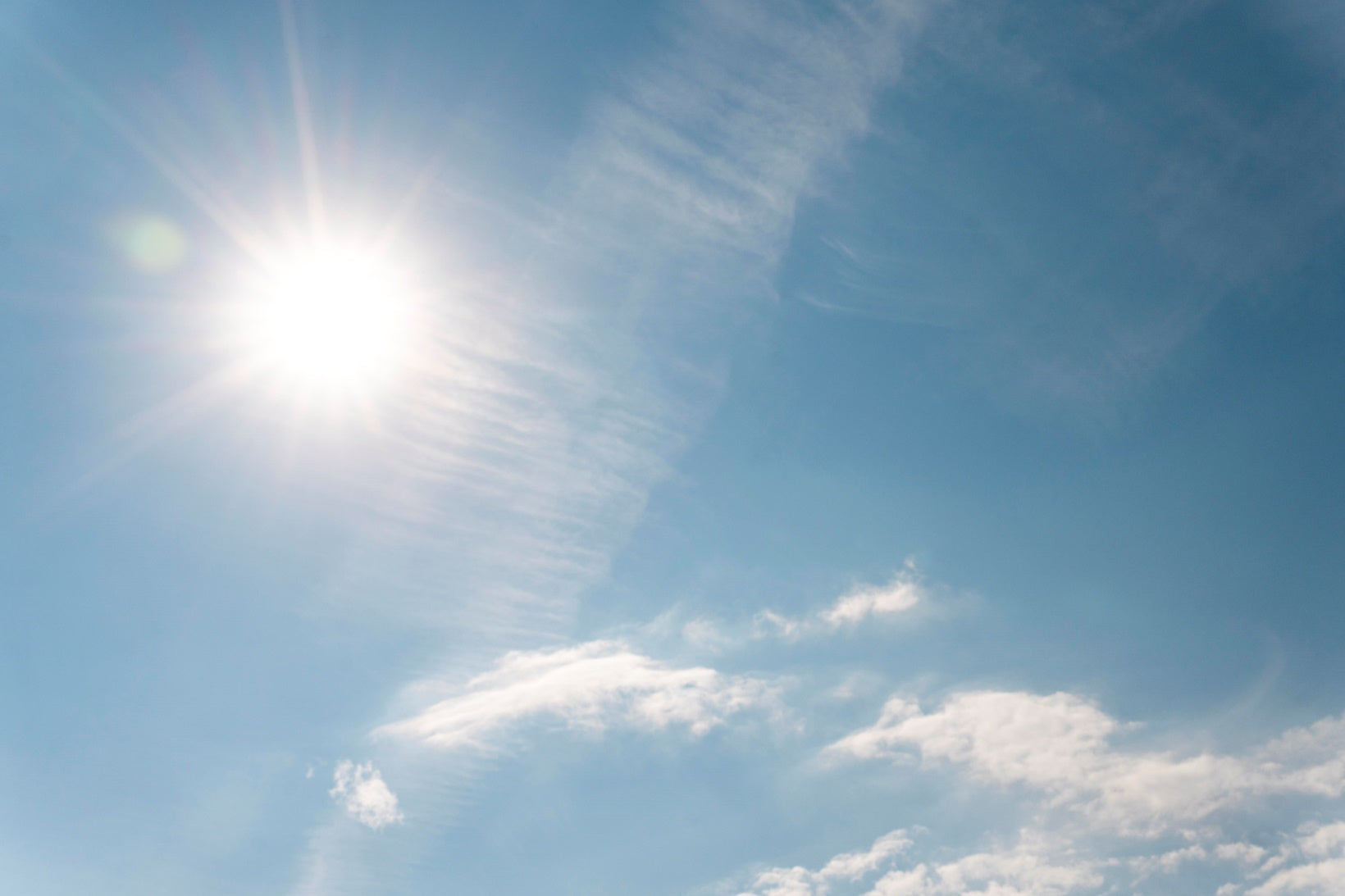 Sun rays on cloudy blue sky