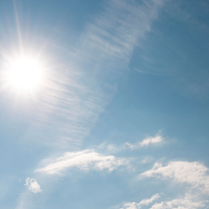 Sun rays on cloudy blue sky